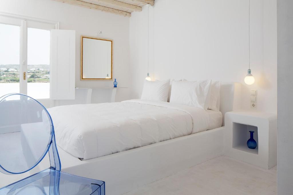 格拉斯托斯亿瑟精品住宿酒店的白色卧室配有床和玻璃桌