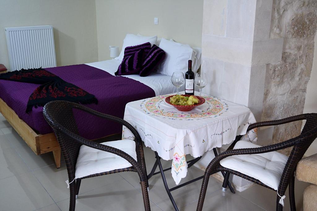 ElefternaArches Eleftherna的一张桌子、一瓶葡萄酒和两把椅子