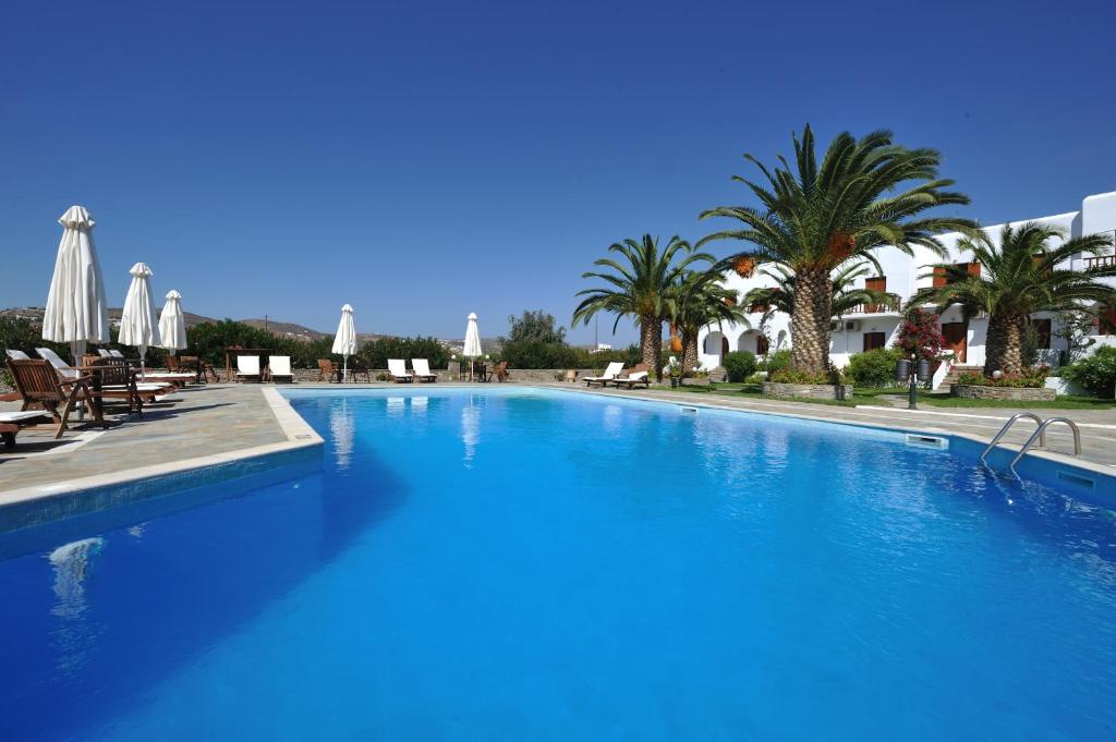 帕罗奇亚埃瑞酒店的一座种植了棕榈树和遮阳伞的大型蓝色游泳池