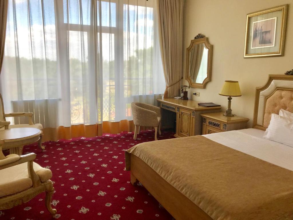 基辅维萨克酒店的酒店客房带一张床、一张书桌和一面镜子