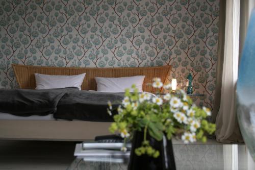 巴特埃姆斯冬博格酒店的一间卧室配有一张床和一张鲜花桌