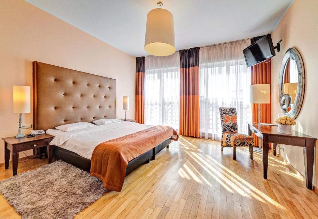 波兹南丹普雷斯提齐酒店的一间卧室配有一张大床和一张书桌