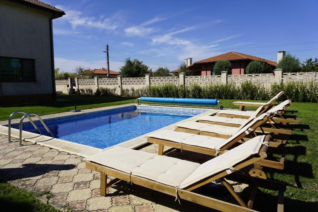 布尔加沃Вила Калиакра - Villa Kaliakra - 3 km to beach Bolata的一个带躺椅的游泳池和一个游泳池