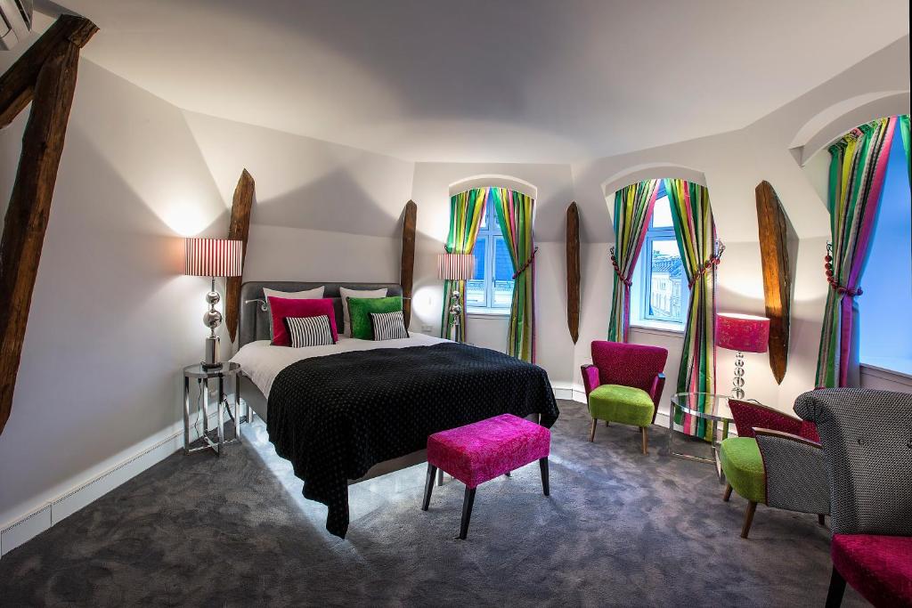 哥本哈根阿布萨隆丹恩斯克食客酒店的一间卧室配有一张床、一些椅子和窗户