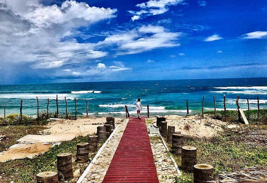 泰巴Casa Taíba Beach Resort的沿着海滩上的红木栈道走的人