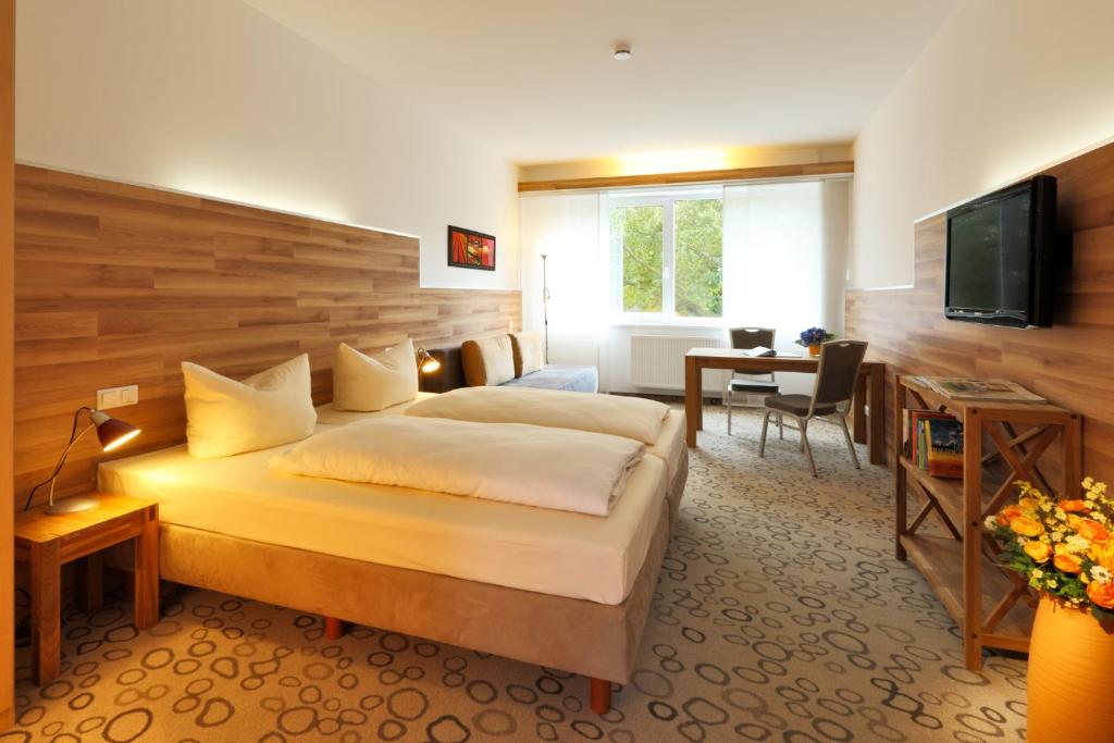 波鸿鲁尔弓佩图公寓式酒店的酒店客房配有一张床、一张书桌和一台电视。