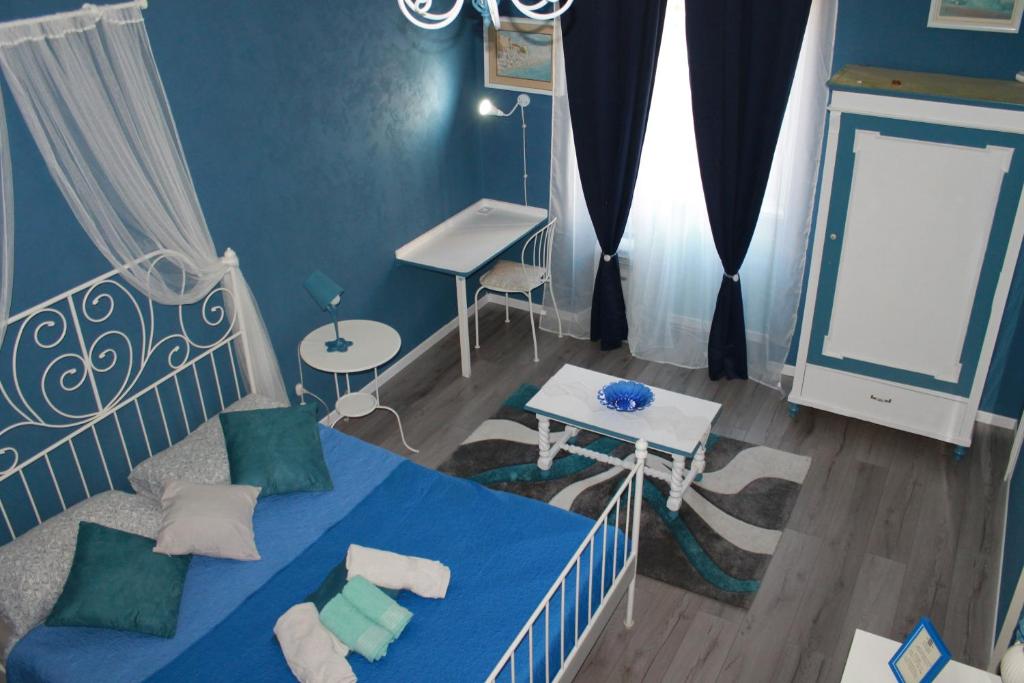 的里雅斯特古旭乐住宿加早餐旅馆的蓝色卧室配有一张床和一张书桌