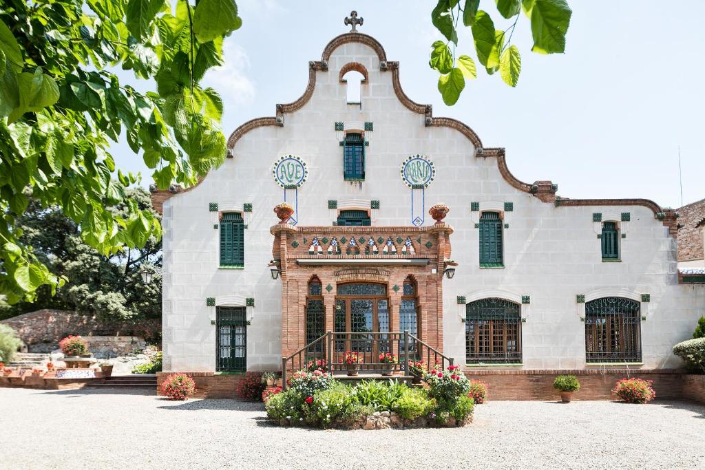 Castellar坎博瑞尔酒店的一座白色的大建筑,设有绿色百叶窗