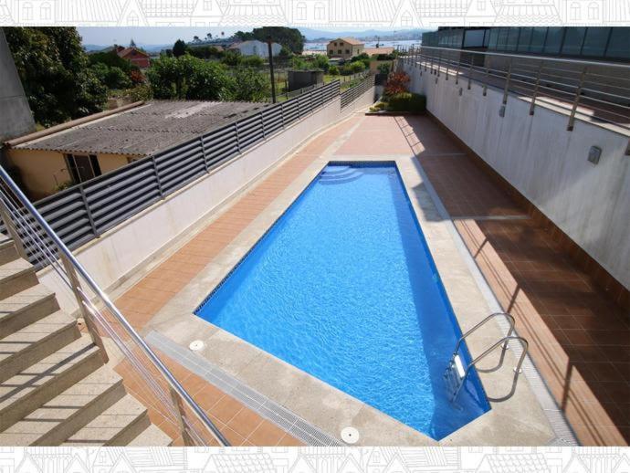 艾利亚德亚罗萨Residencial Cabodeiro的建筑物一侧的游泳池