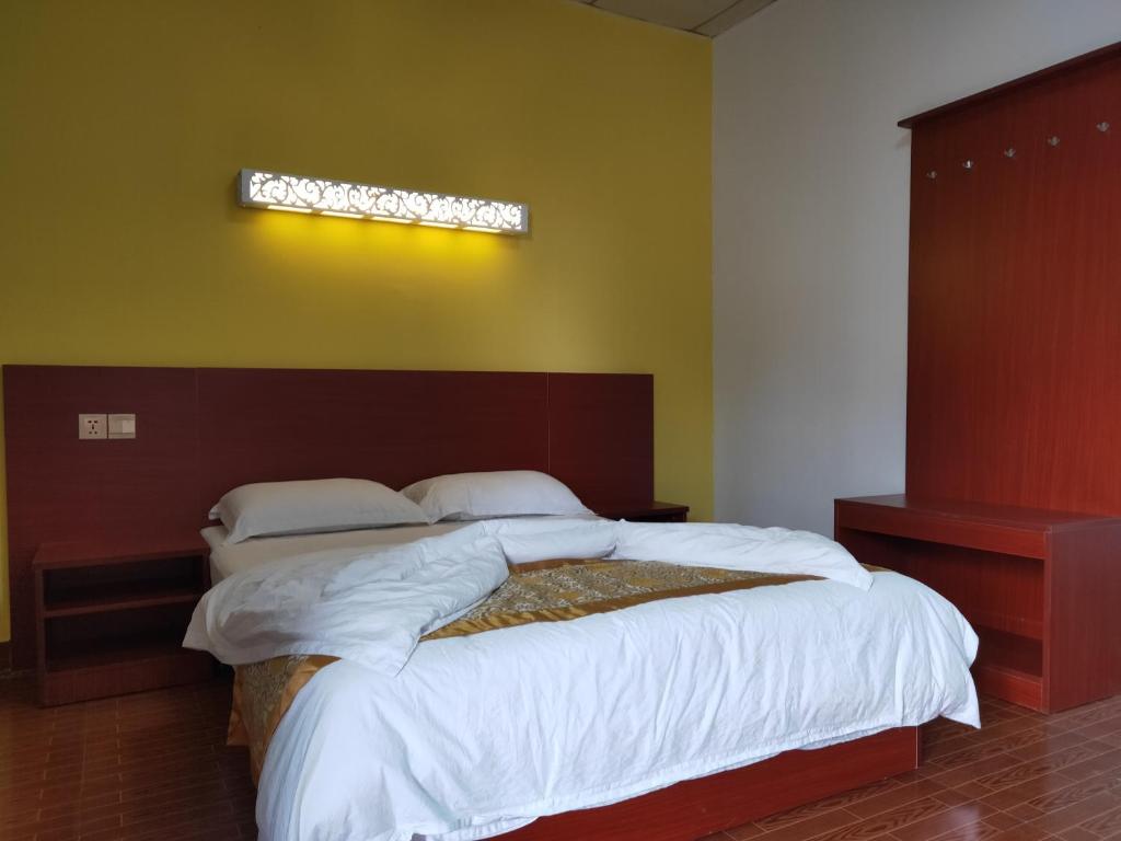 帝力CHONG TI HOTEL的一间卧室配有一张带白色床单的大床