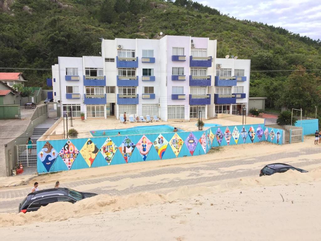 弗洛里亚诺波利斯Via Praia Apart Hotel的海滩上的一座建筑,设有游泳池
