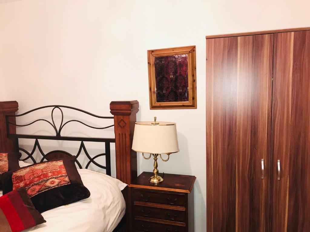 哈罗Modern cosy room with private bathroom的一间卧室配有床、梳妆台和台灯。