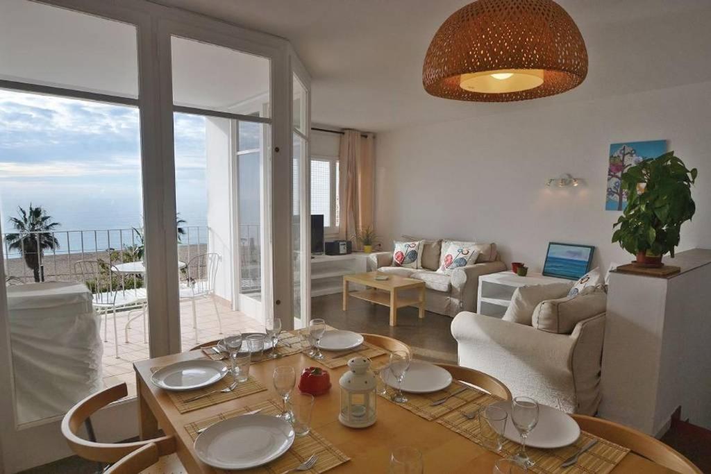 卡内·德·玛尔Duplex en frente de la playa al lado de Barcelona的客厅配有桌子,享有海景