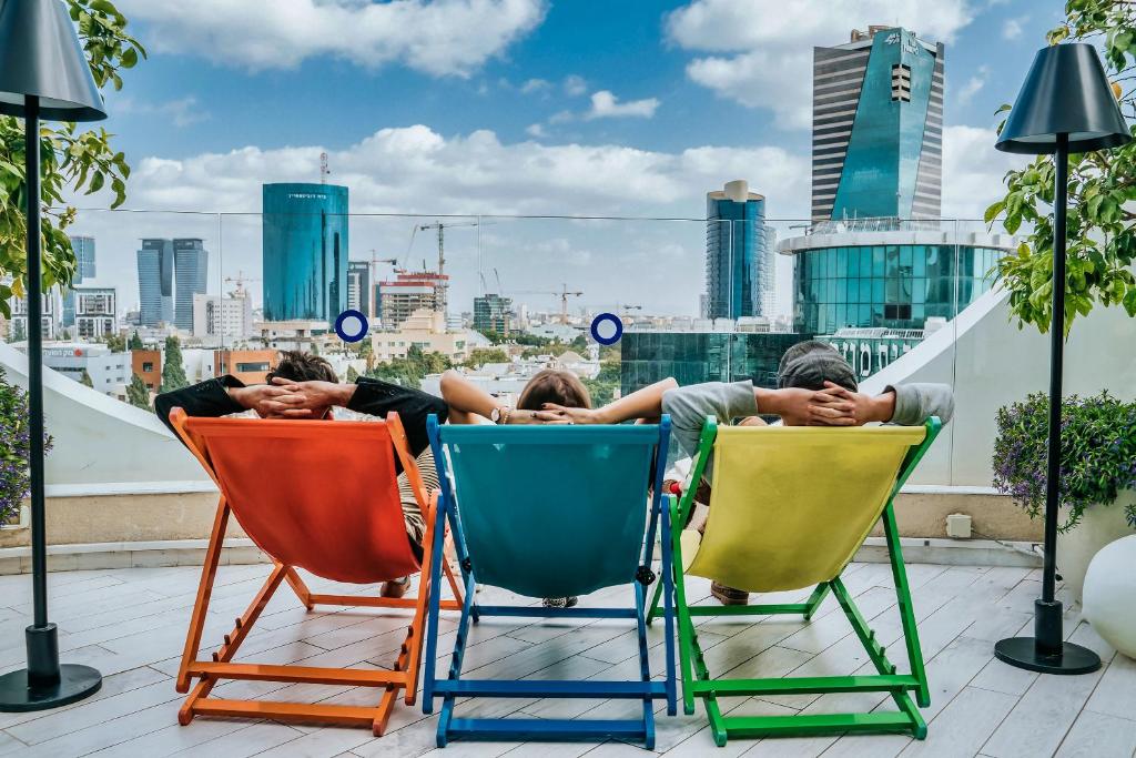 特拉维夫罗斯柴尔德特拉维夫65酒店 - 阿特拉斯精品酒店的一群人睡在屋顶的椅子上