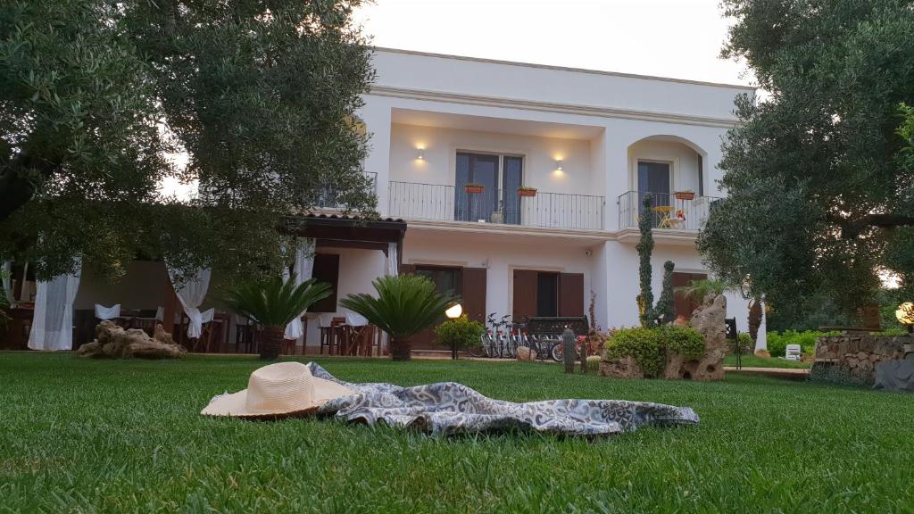 切萨雷奥港Villa Sofia Affittacamere的坐在房子前面的草上的一个帽子