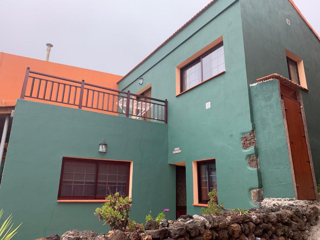 El Pinar del HierroCasa Tanajara的蓝色和绿色的房子设有阳台