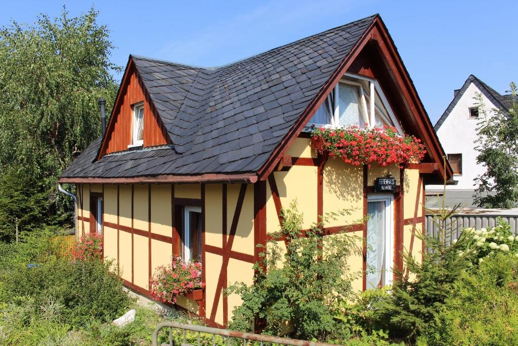 沃尔肯施泰因Ferienhaus Neubert的黄色和橙色的黑色屋顶房屋