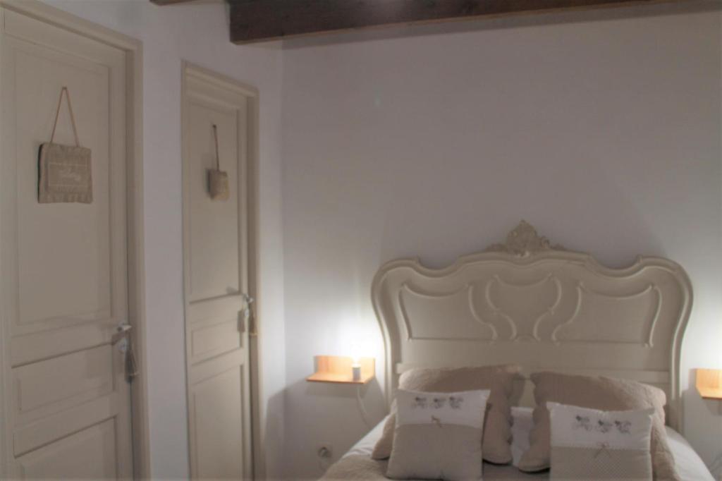 卡米尔斯Chambre du Rouard LE RUISSEAU的卧室配有白色的床和2个枕头
