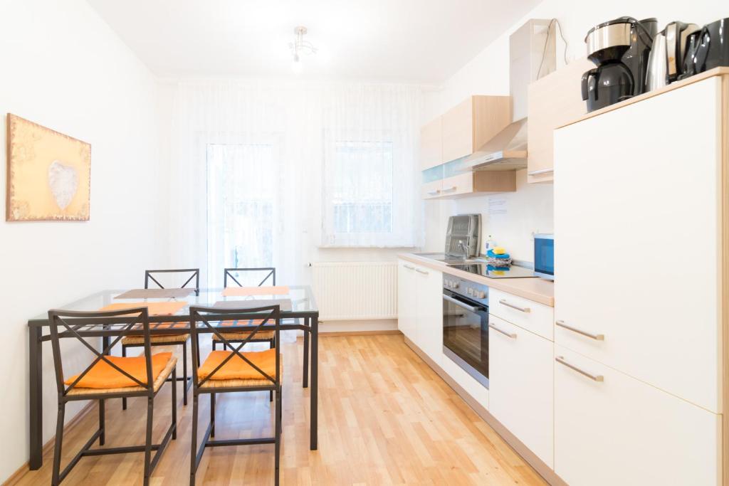 菲尔特Private apartments with direct subway entrance的厨房配有白色橱柜和桌椅