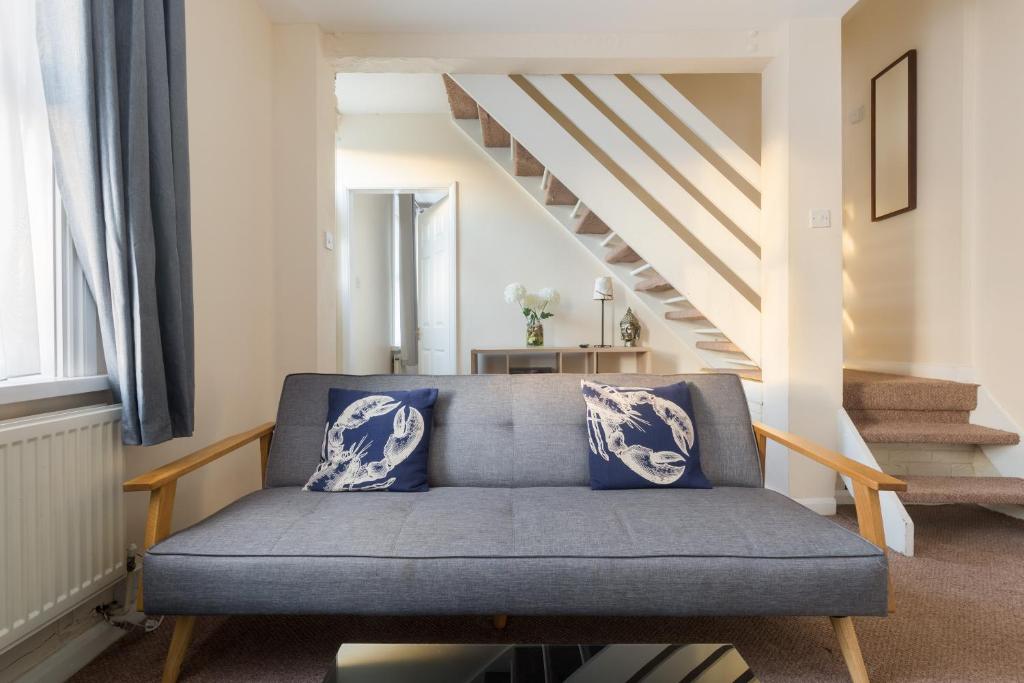 利明顿温泉Well presented 2 bedroom house - sleeps four的客厅设有蓝色的沙发和楼梯。