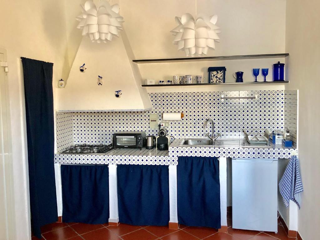 热那亚La Casa di Dory的厨房配有蓝色窗帘和台面