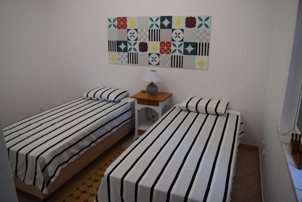 拉戈斯CasaDuarte Courtyard (1 bedroom Apt.)的两张睡床彼此相邻,位于一个房间里
