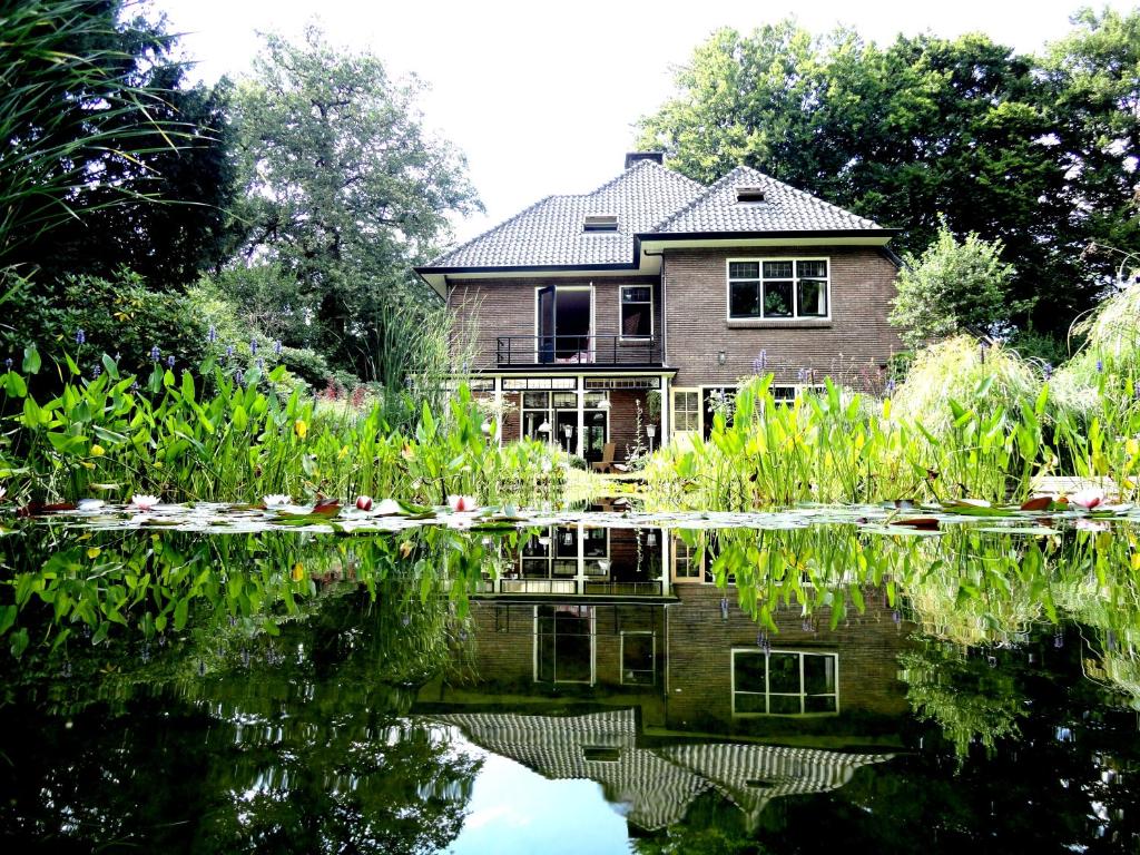 比尔特霍芬Apartment in Romantic Villa的池塘水中反映的房子