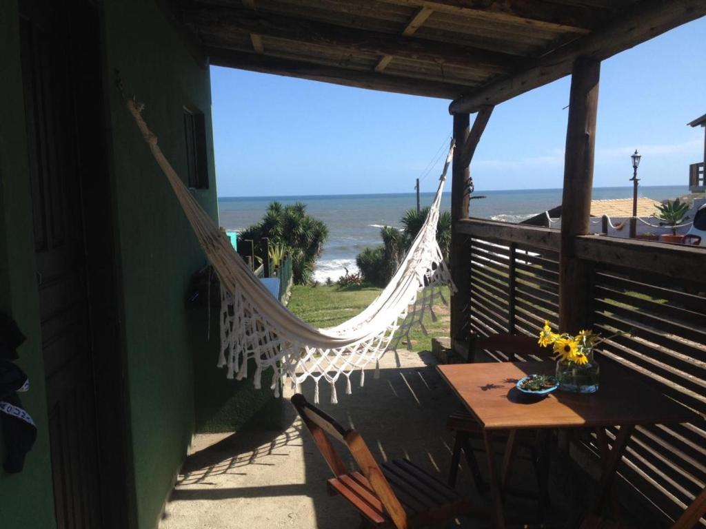 拉古纳Casa verde的俯瞰着海滩的房屋门廊上的吊床