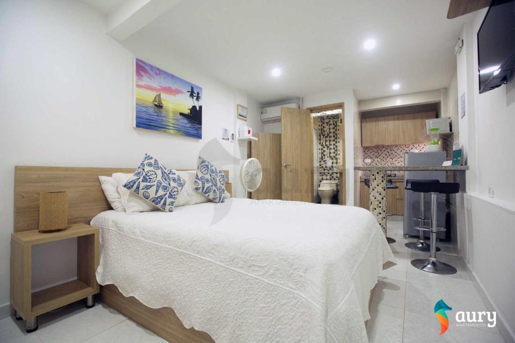圣安德烈斯Apartamentos Aury的一间带白色床的卧室和一间厨房