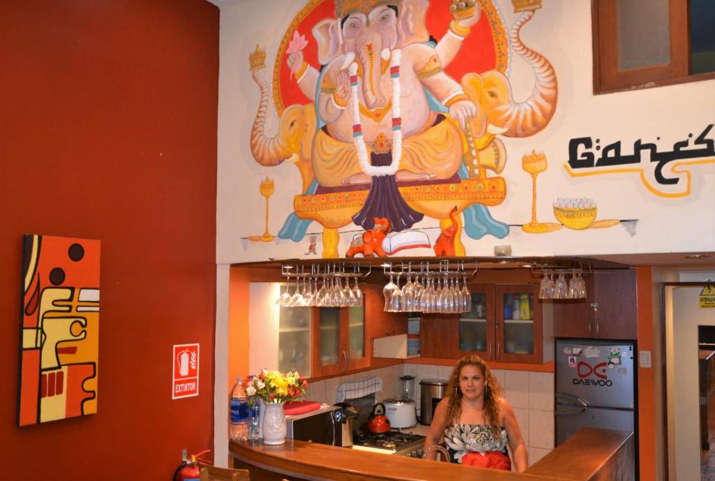 利马苏斯皮罗印加旅舍的站在厨房里,墙上挂着一幅大画的女人