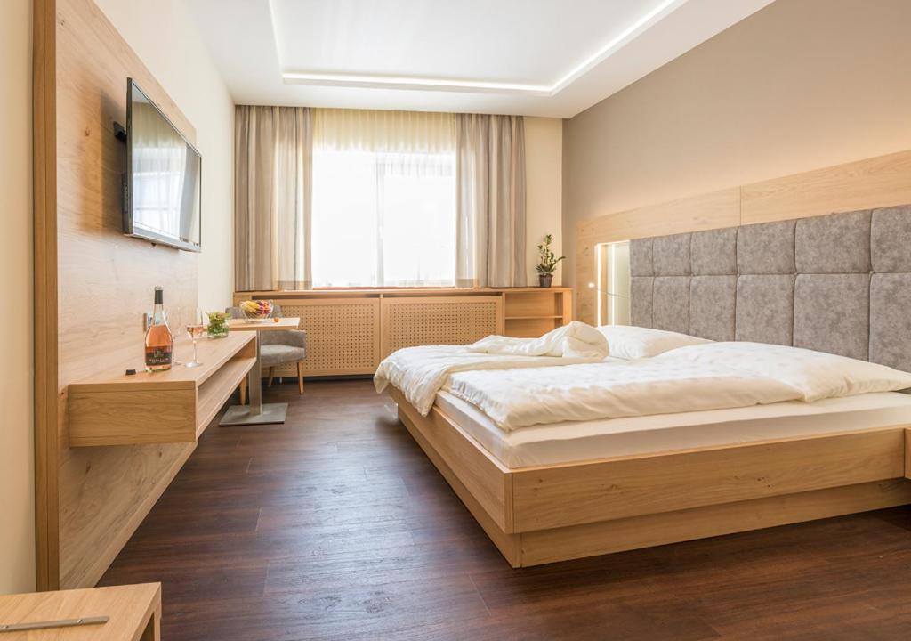雷茨Weingut Breitenfelder的一间卧室配有一张大床和一张书桌