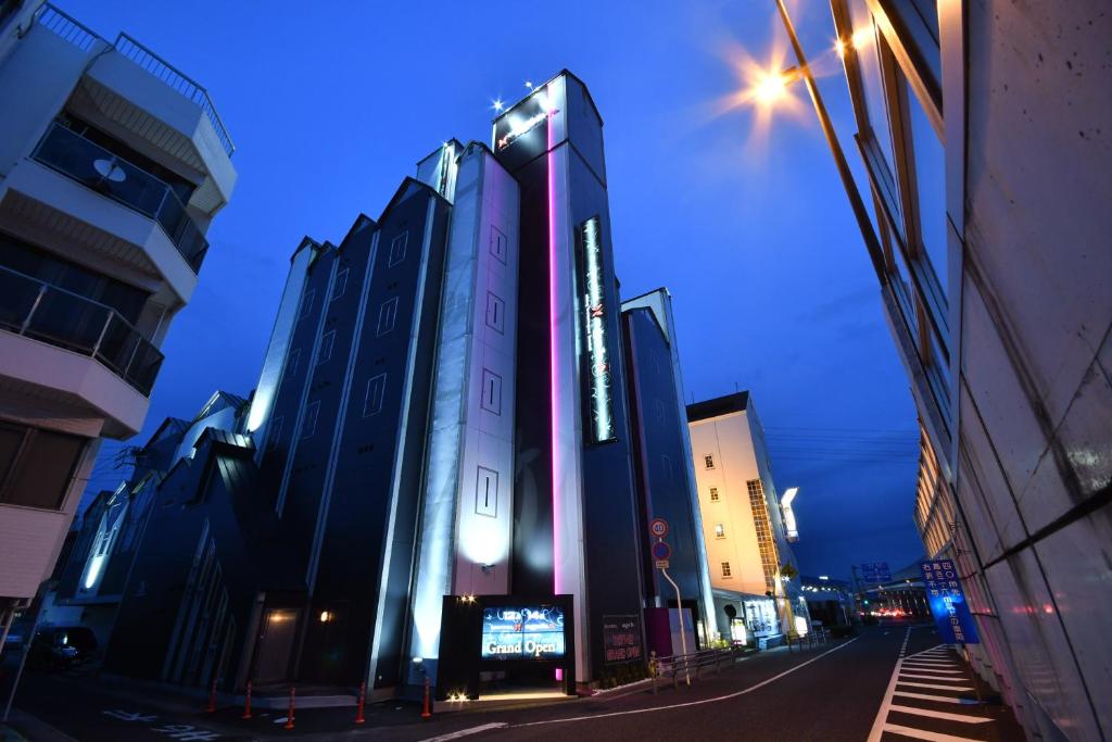 冈山Hotel agehA cinq boutique (Adult Only)的夜幕降临的城市街道上一座高楼