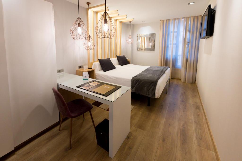 奥维多弗雷拉酒店的酒店客房配有一张床、一张书桌