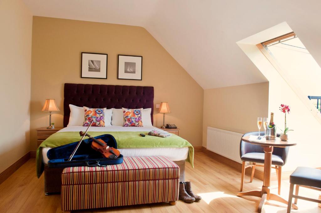 金瓦拉吉纳瓦酒店的一间卧室,配有一张小提琴床,位于一个搁脚凳上