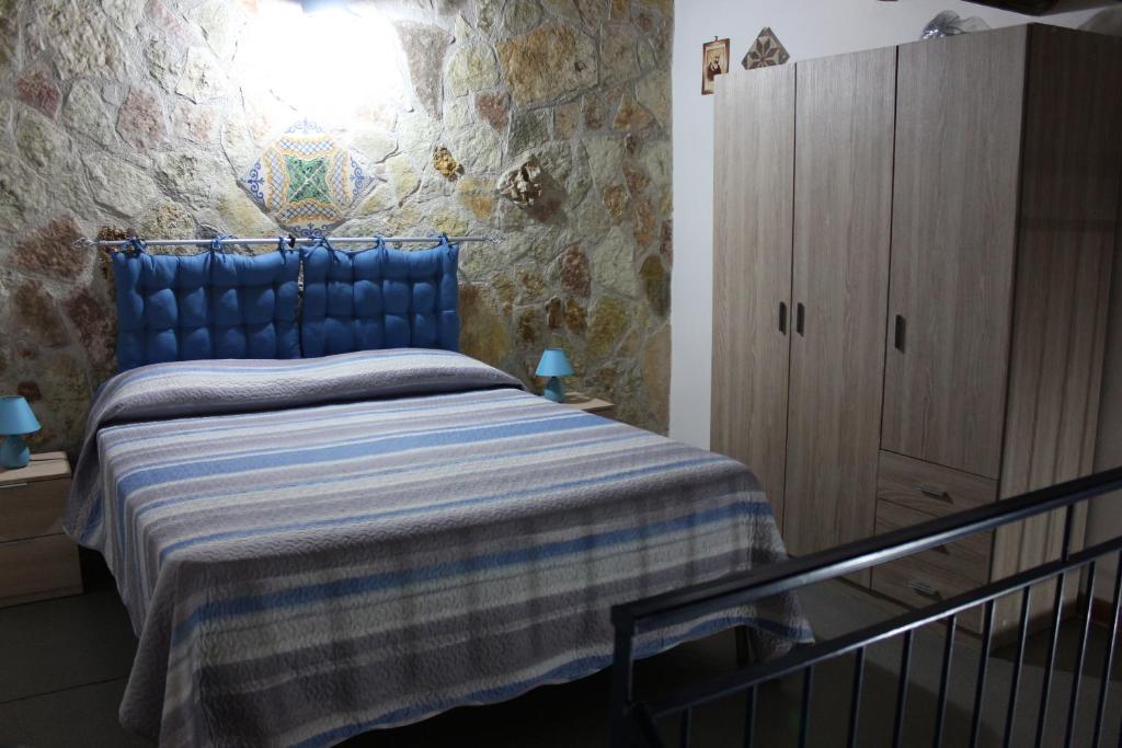 卡斯泰拉马莱Casa Azzurra的一间卧室配有蓝色的床和木制橱柜