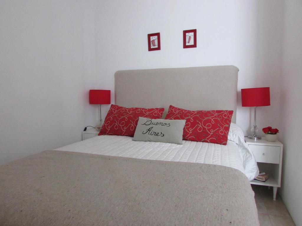 布宜诺斯艾利斯Departamento Tango & Resto-Hospital Ital y Sanatorio Güemes的一间卧室配有一张带红色枕头的床和两盏灯。