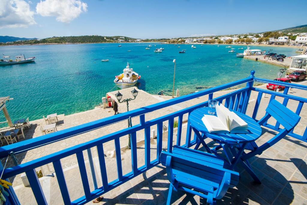 艾丽奇Angeliki Seaside Hotel的阳台上的两把蓝色椅子,有水