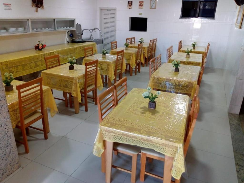 阿拉卡茹Hotel Praia e Mar的用餐室配有桌椅和鲜花