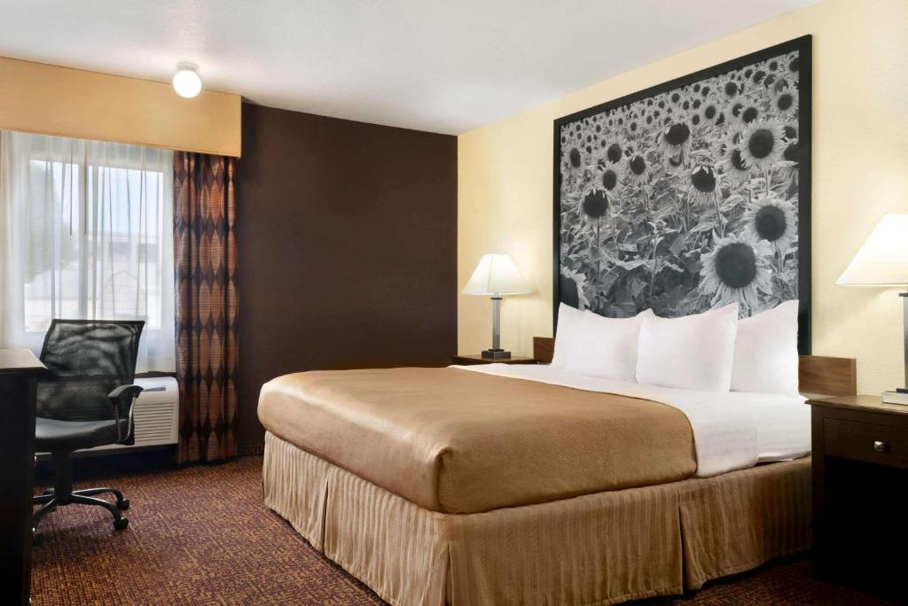 德梅因德梅因速8酒店的酒店客房配有一张床、一张桌子和一把椅子。