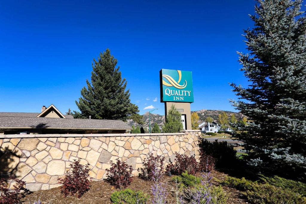 埃斯蒂斯帕克Quality Inn near Rocky Mountain National Park的石墙旁优质旅馆标志