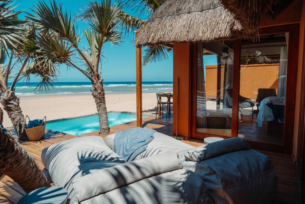 Cabo NhamuaEclectic Beach Retreat的海滩上的客厅配有沙发