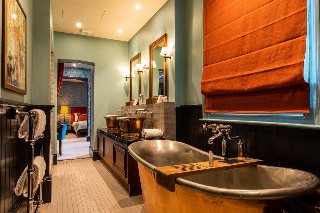 伦敦福克斯安可酒店的浴室配有木制浴缸和水槽