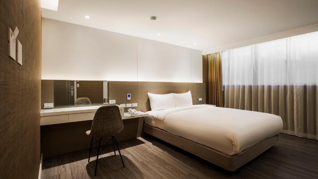 台北蒲园饭店的酒店客房配有一张床和一张带椅子的书桌