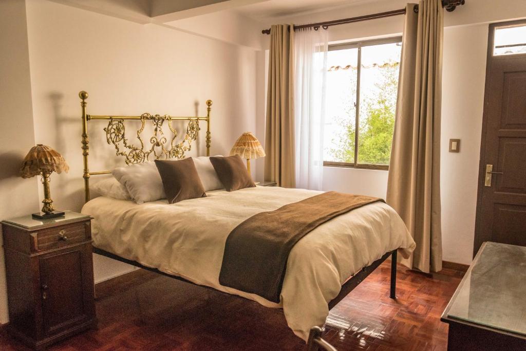 苏克雷El Jardin De Su Merced B&B的一间卧室设有一张大床和一个窗户。