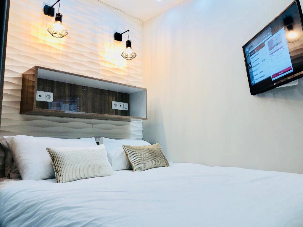 博索莱伊Chambre Love Luxe Monaco的卧室配有白色的床和平面电视。