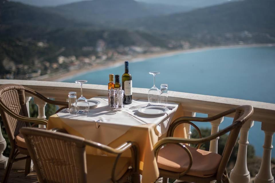 埃费奥纳斯PORTO TIMONI的阳台上配有带葡萄酒瓶和玻璃杯的桌子