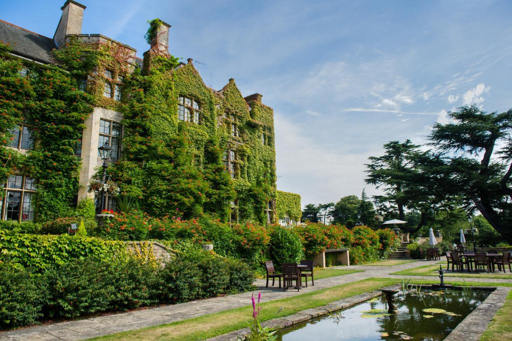 巴格肖特Pennyhill Park Hotel and Spa的前面有池塘的建筑