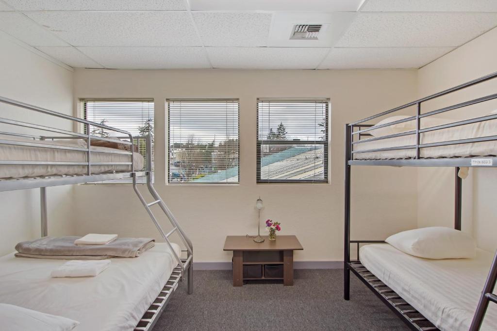 星期五港San Juan Island Hostel的带桌子和窗户的客房内的两张双层床