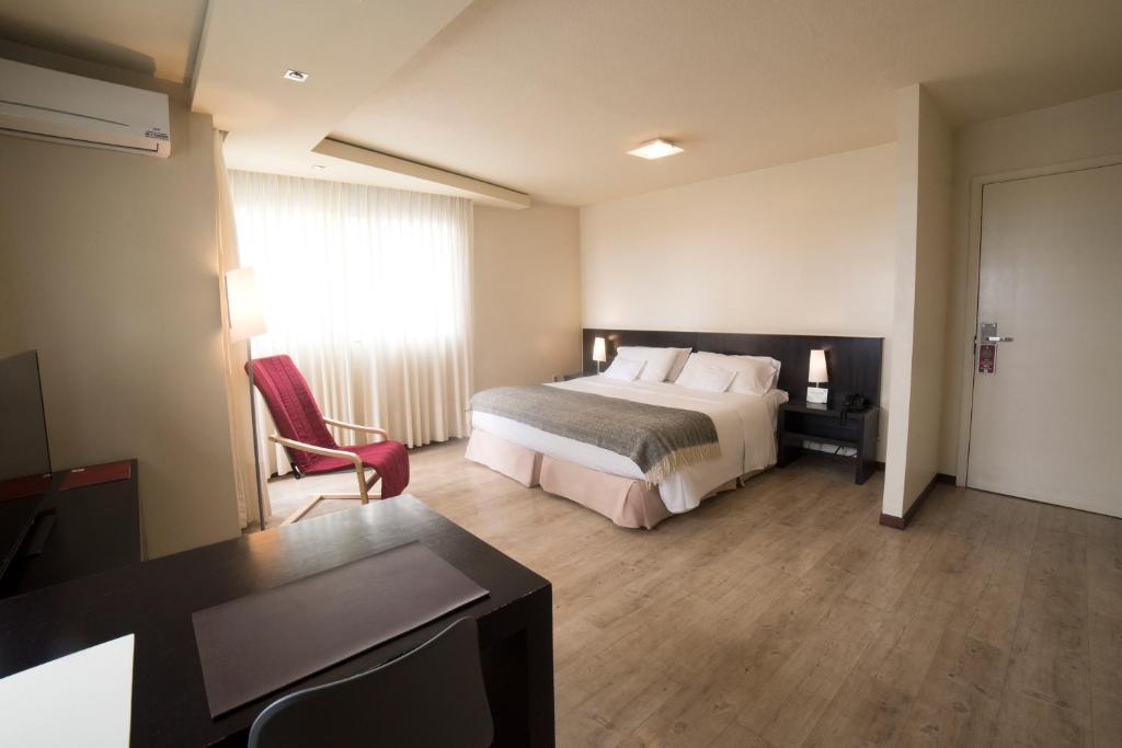 蒙得维的亚27 Suites Hotel的配有一张床和一张书桌的酒店客房
