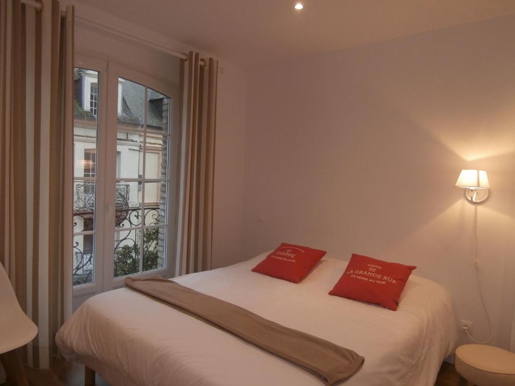 迪耶普au Claire de lune的一间卧室配有一张带两个红色枕头的床